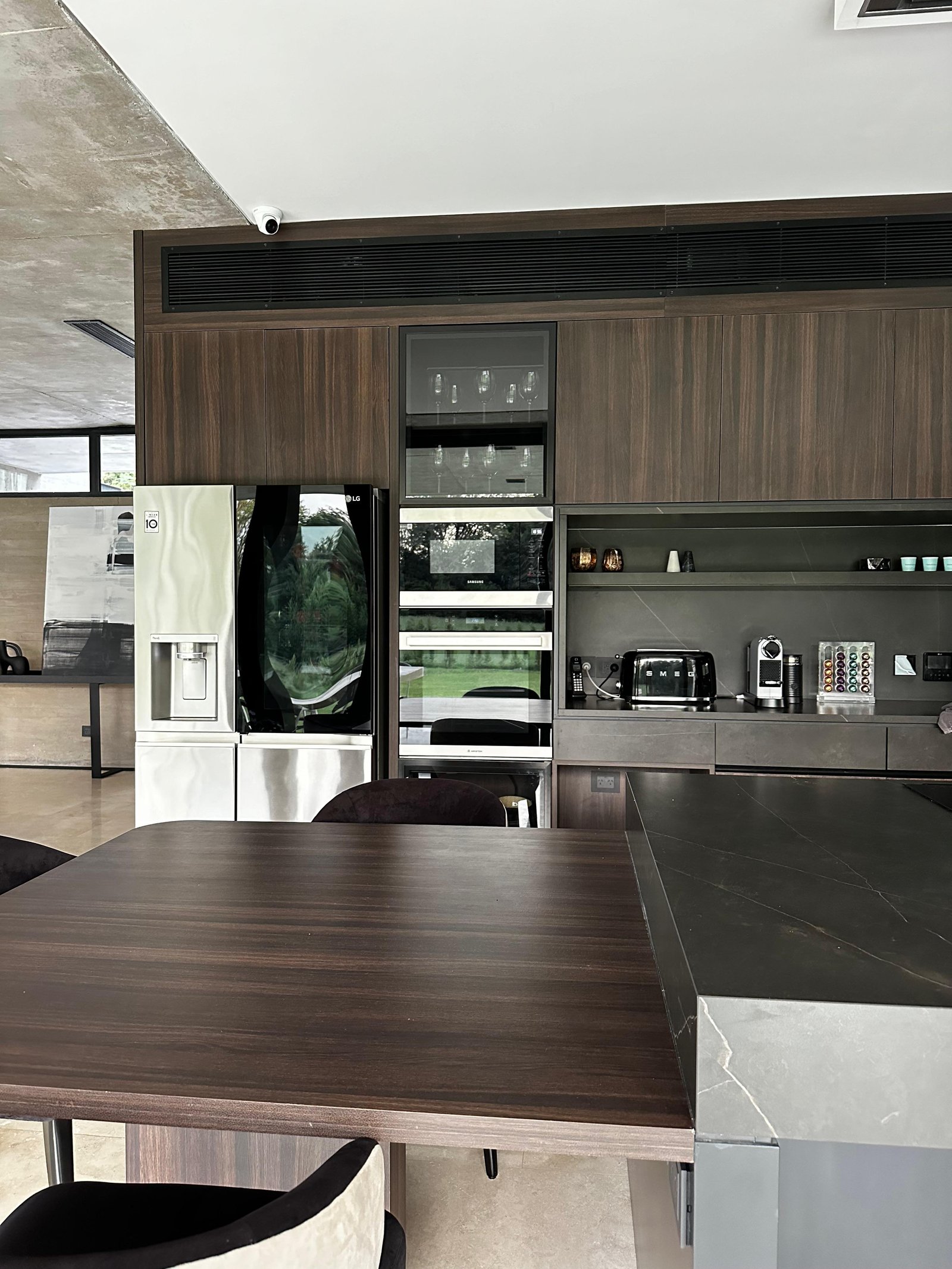 Cocina moderna de planta abierta con isla de comedor y gabinetes de madera oscura — proyecto Infinito - Estudio Made it , por ABEJA CONCEPT, en Chubut 415